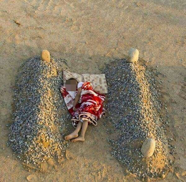 Fotoprojekt: Das Foto zeigt einen Jungen, der augenscheinlich zwischen den Gräbern seiner Eltern im Sand schläft