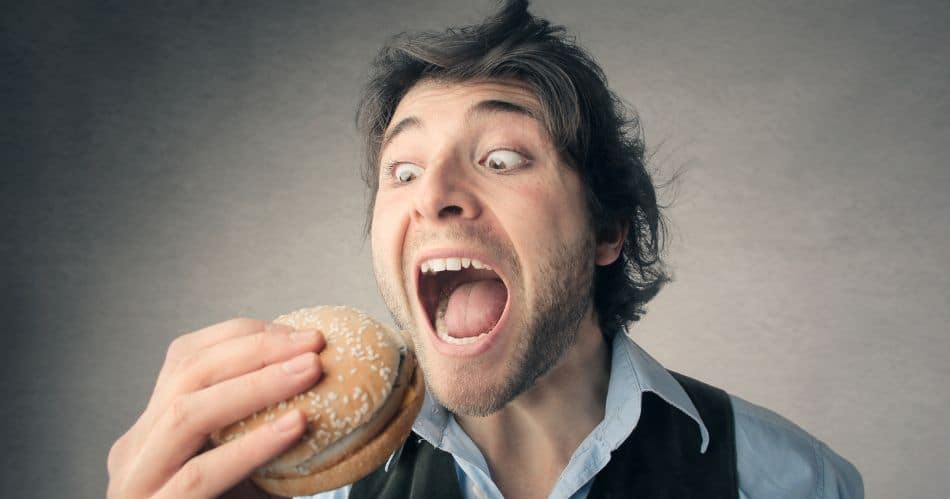 Heißhunger: Tipps gegen Heißhunger? So bleibt der Blutzucker im Gleichgewicht, Bild: Pixabay, Ein Mann mit weit aufgerissenen Augen will in einen Hamburger beißen